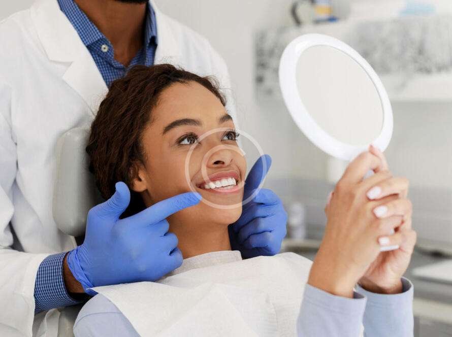 Female smiling using a mirror