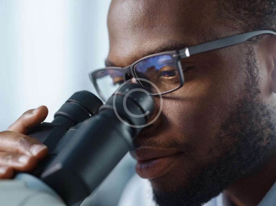 Male doctor looking through microscope