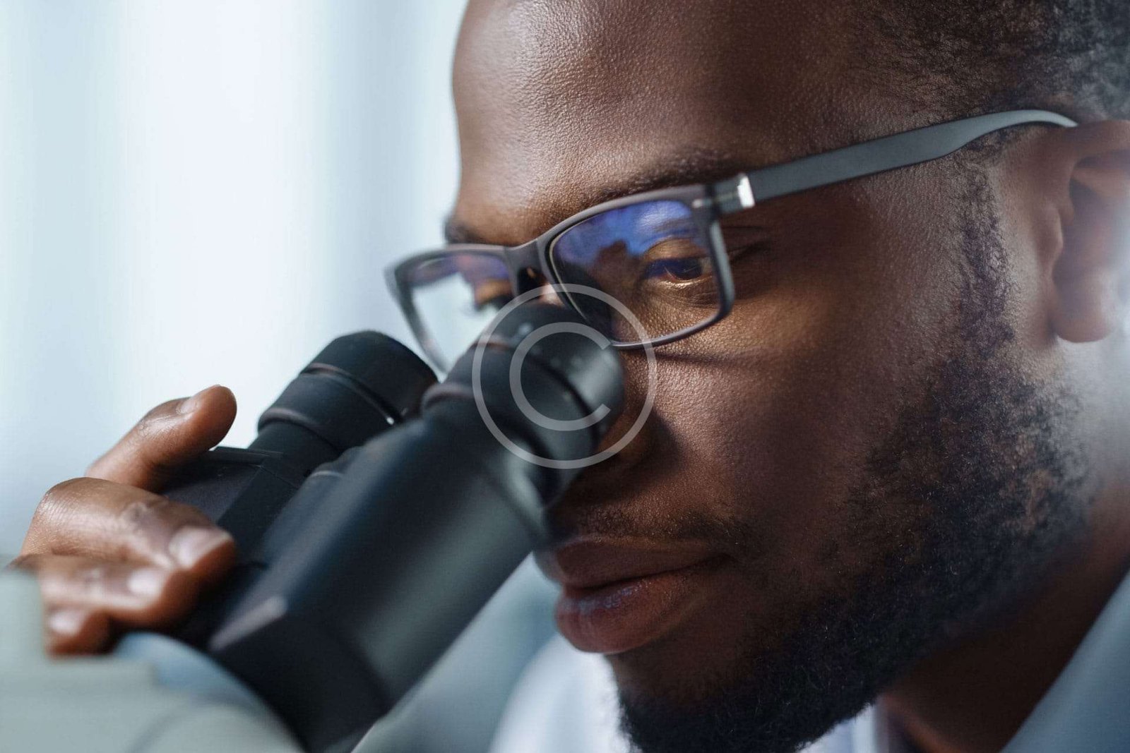 Male doctor looking through microscope