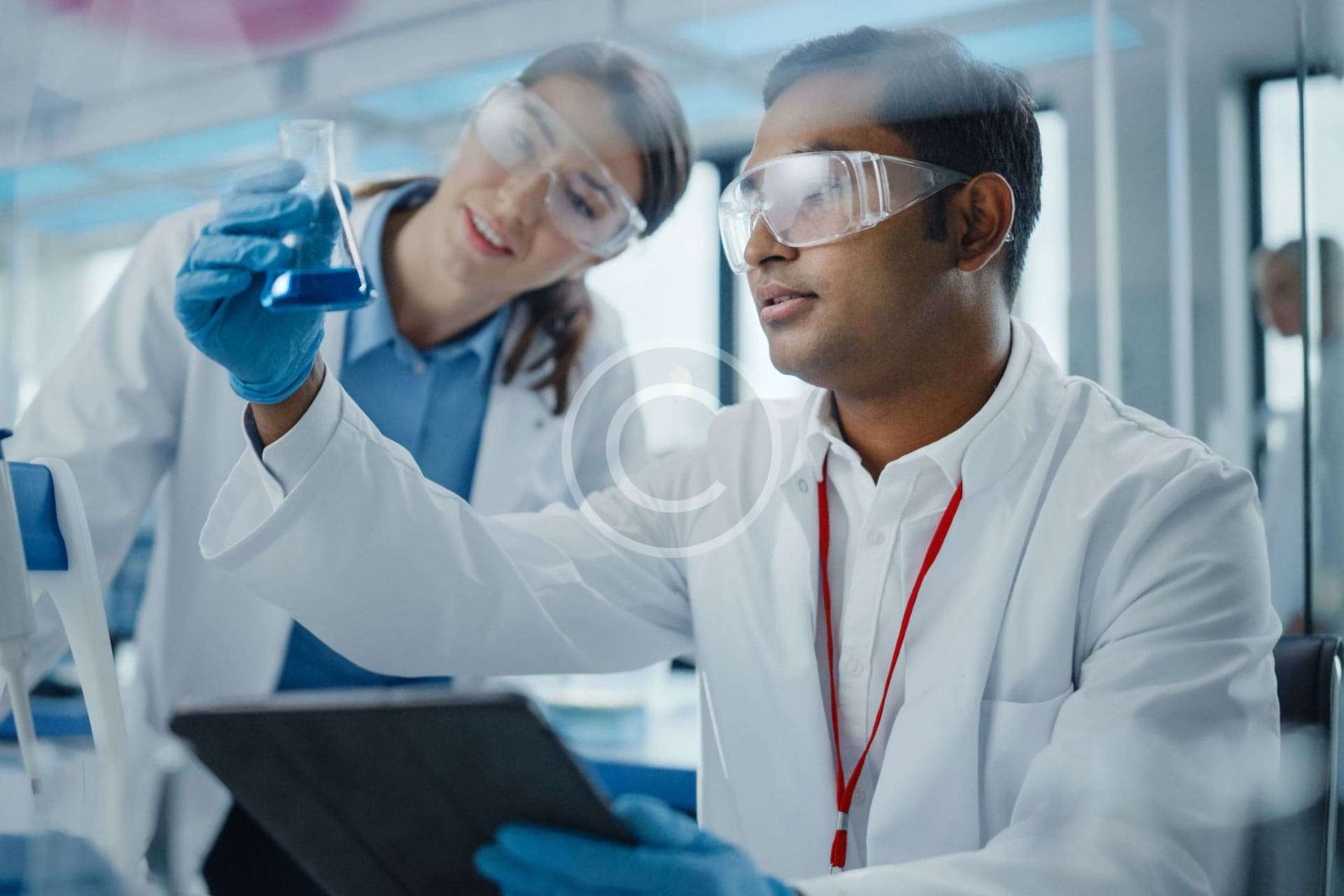 Two medical pharmacists analyzing chemicals in bottle