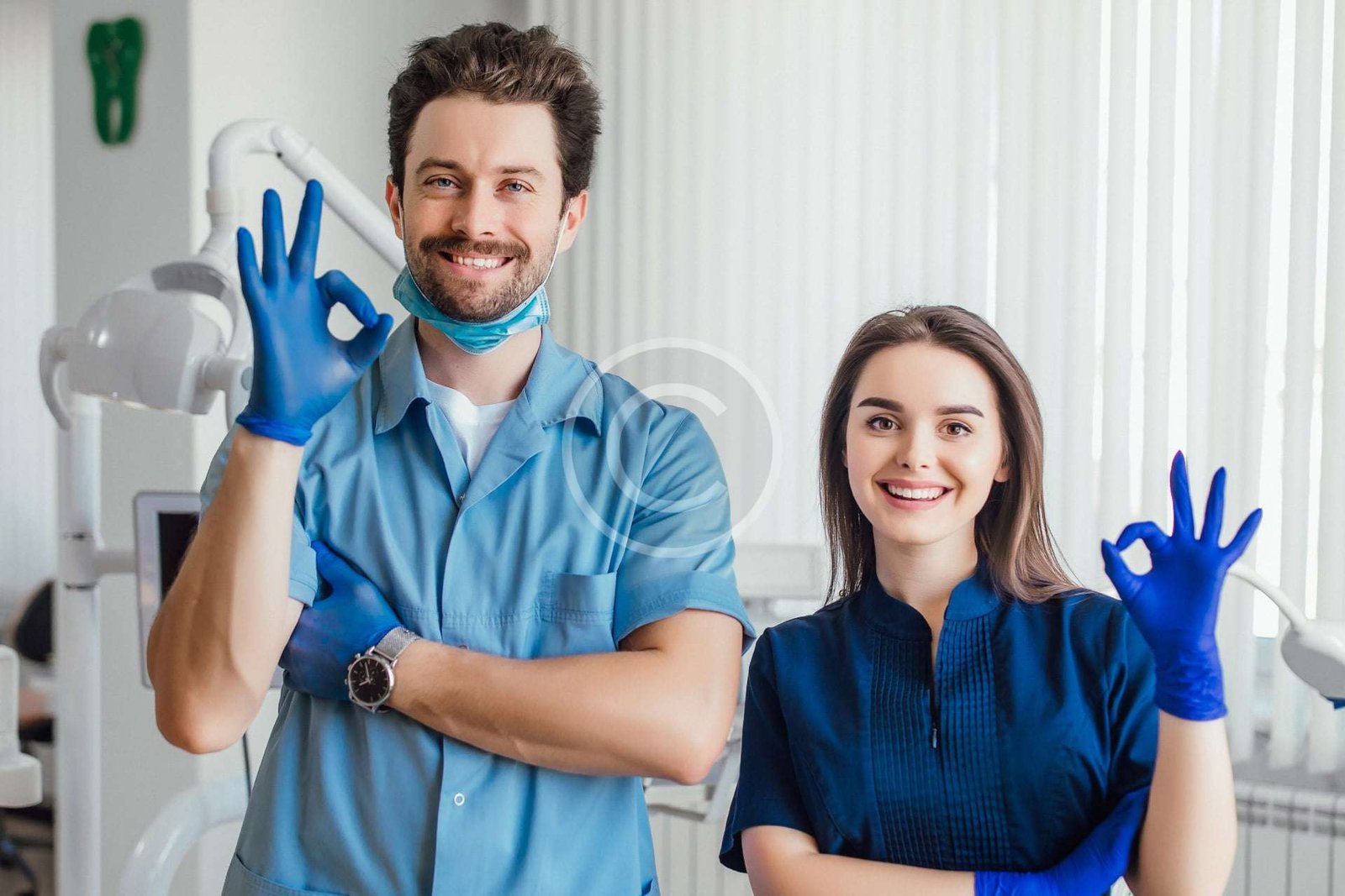 Male and female doctors making an OK hand gesture