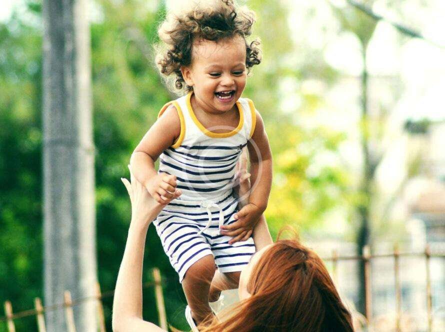 Adult woman lifting a child in her arms