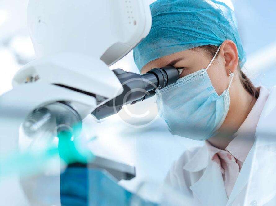 Medical scientist looking through microscope