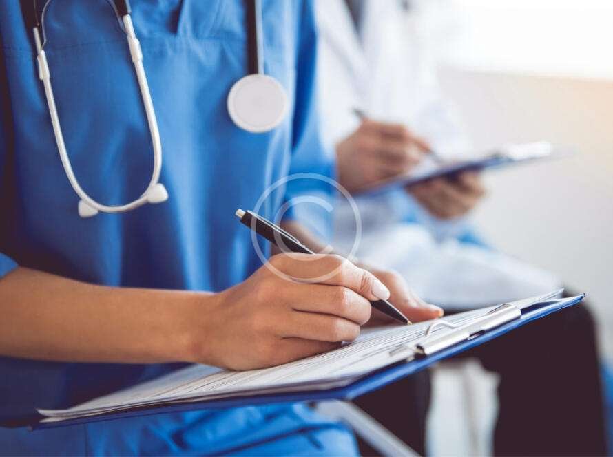 Nurse writing on clipboard