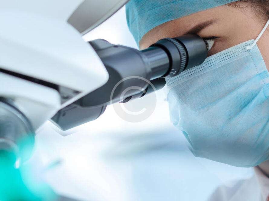 Medical scientist looking through microscope