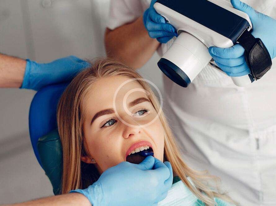 Little girl receiving teeth-whitening treatment from a dentist