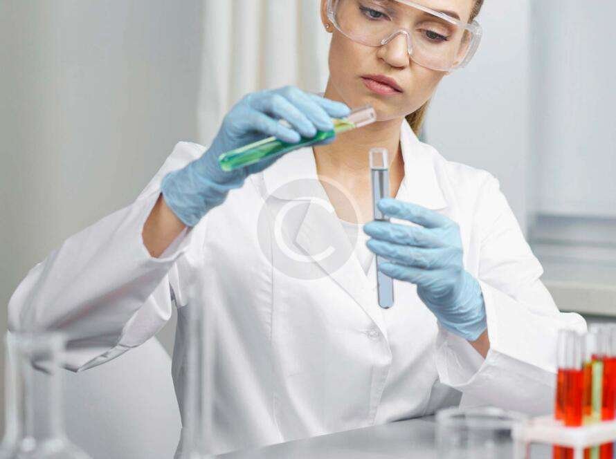 Female scientist mixing liquids in laboratory flasks