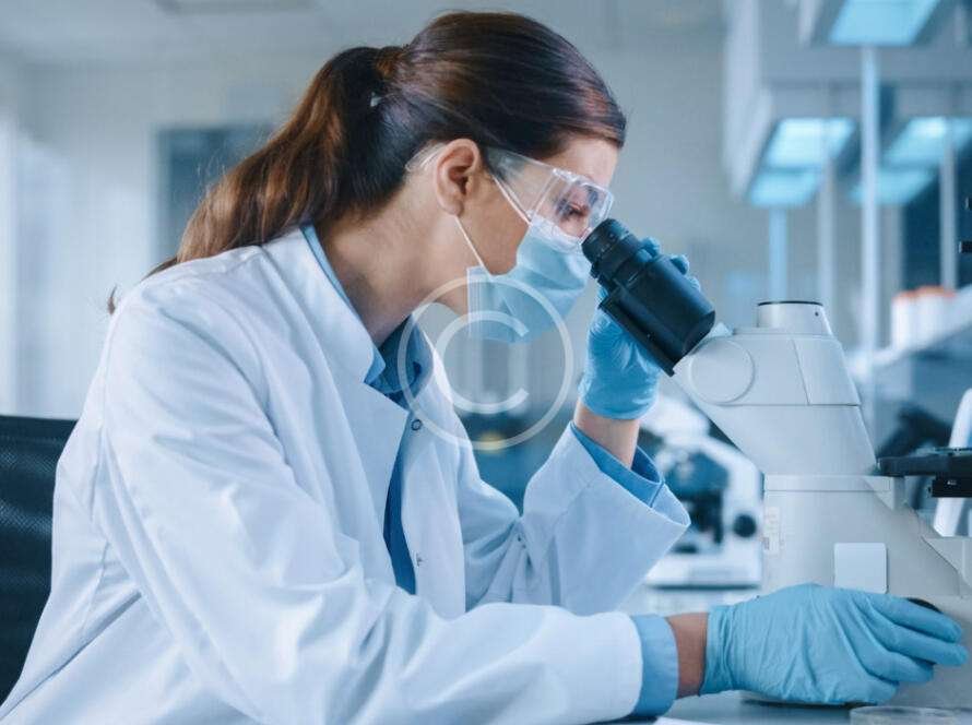 Female medical scientist looking through microscope