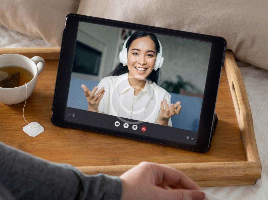 Woman wearing headphones chatting with someone on a video call