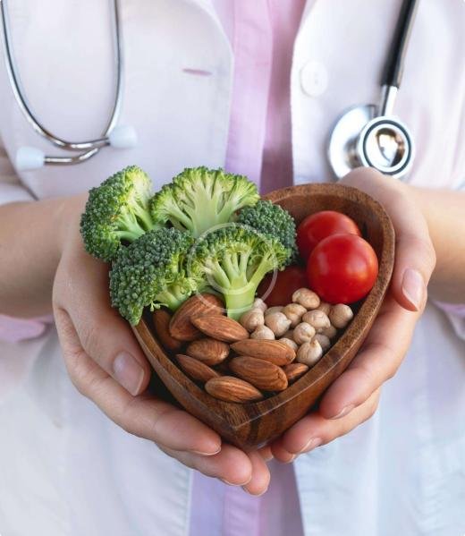 Doctor holding a bowl of broccoli, tomatoes, almonds, and chickpeas
